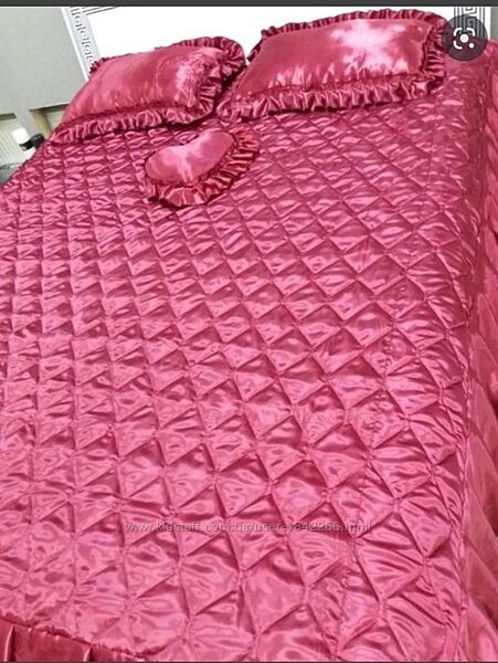 Яскраве рожеве стьобане покривало с подушками на ліжко